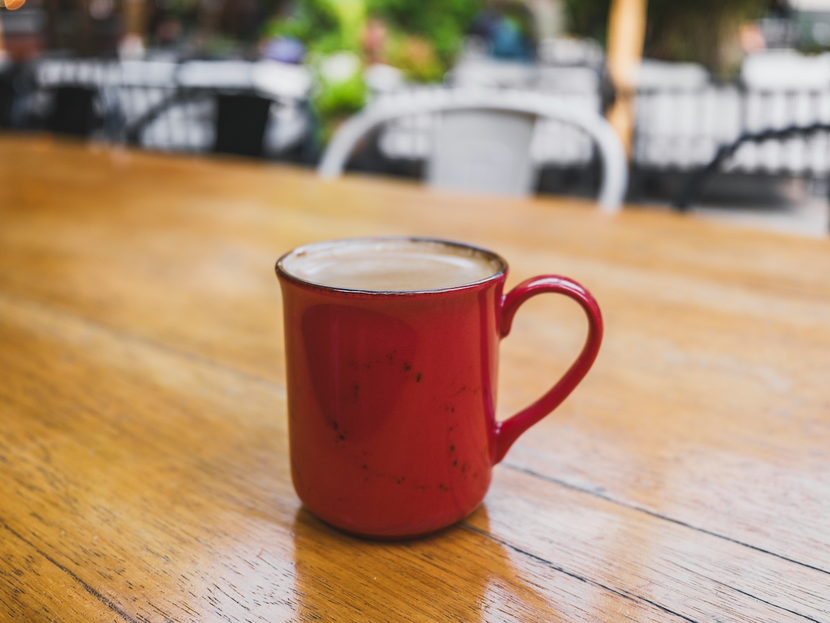 Steaming coffee mug on a wooden table in warm morning light